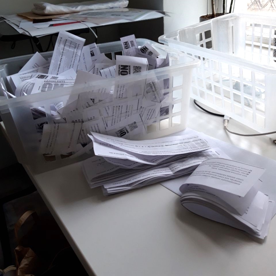 Kuva työpöydästä, jolla on paperilomakkeita sekä pinoissa että laatikon täydeltä