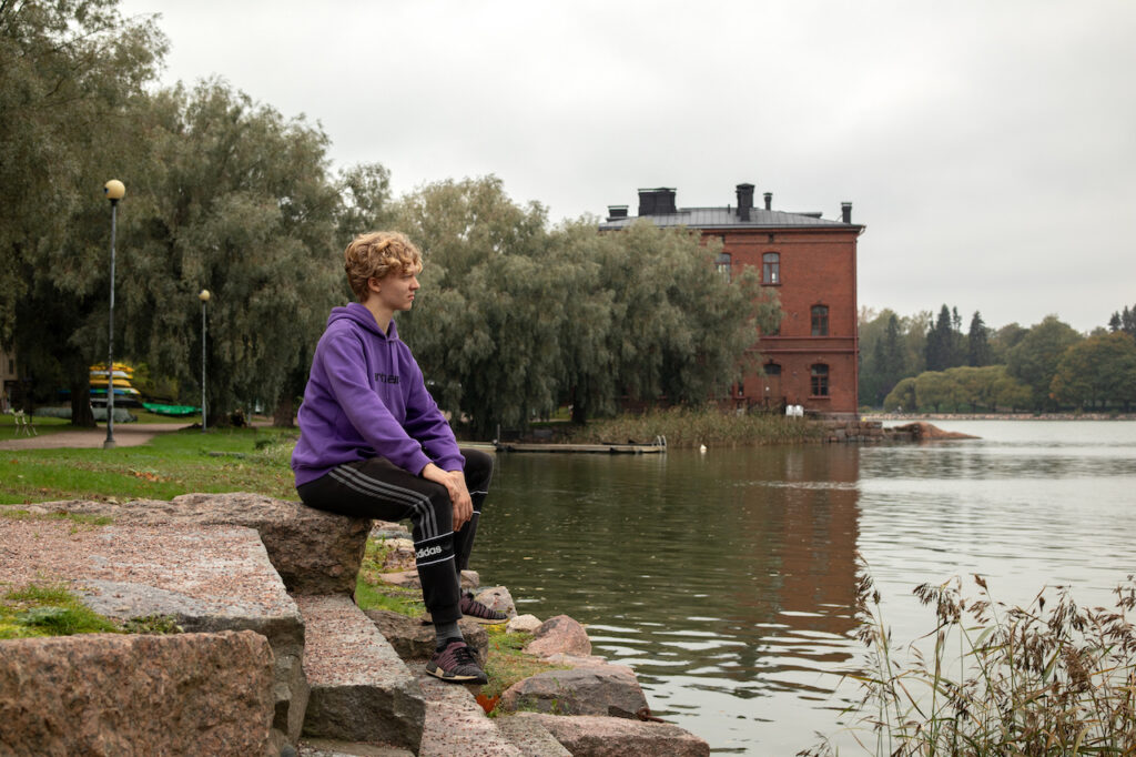 Kuvassa nuori mies katselee Lapinlahden rannan yli merelle.